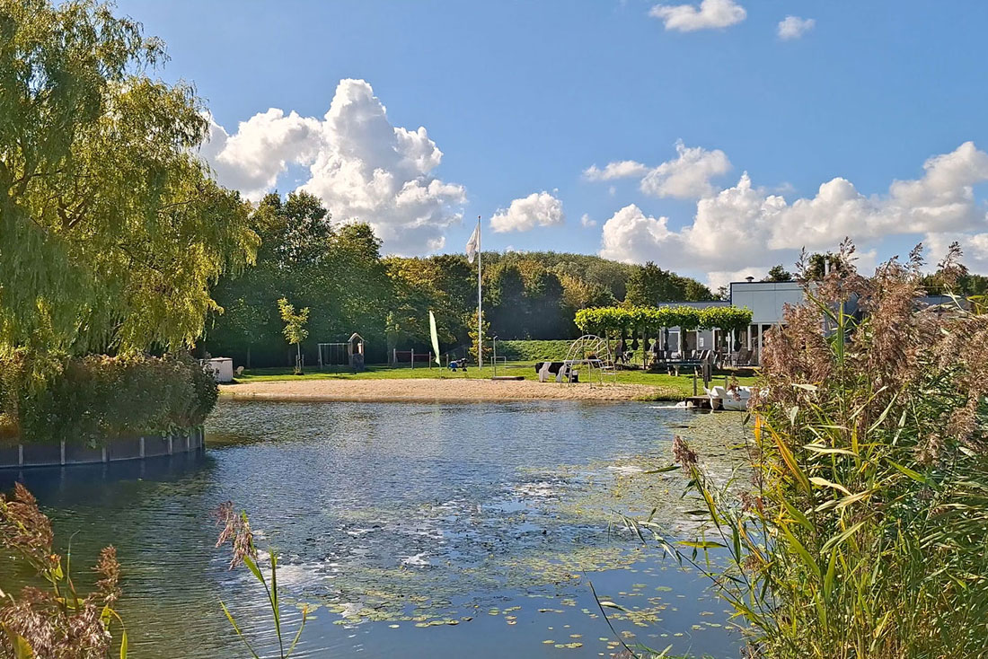 Natural swimming pond with sandy beach at De Brongaard